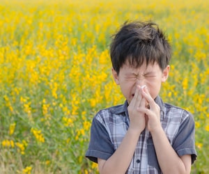 a boy sneezing in a field