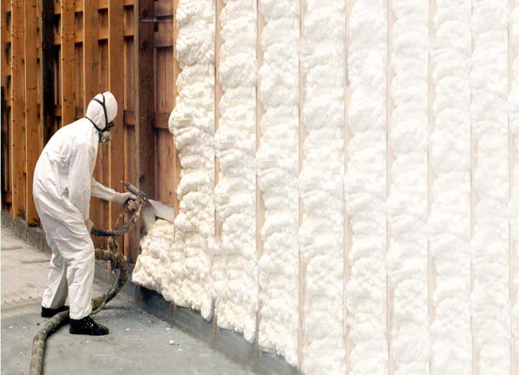 A man spraying insulation on a wall